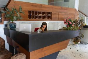 a woman sitting at a desk with a laptop at Hotel Iris in Genoa