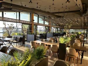 a restaurant with tables and chairs and plants at 01 Nova Otel in Didim +48 photos