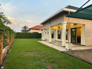 a house with a green lawn in front of it at Cento Stalloni in Kigali
