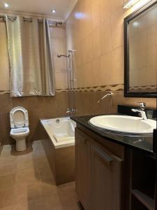 a bathroom with a sink and a toilet and a shower at Cento Stalloni in Kigali