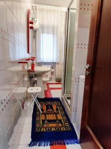 La salle de bains est pourvue d'un lavabo, de toilettes et d'un tapis. dans l'établissement Camera zona TRIBUNALE COSENZA, à Cosenza