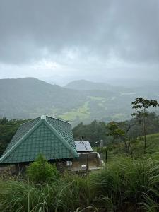 ein Gebäude mit einem grünen Dach auf einem Hügel in der Unterkunft Three Creeks Matale in Matale