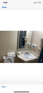 a bathroom with a toilet and a sink and a mirror at Regency Inn in Perry
