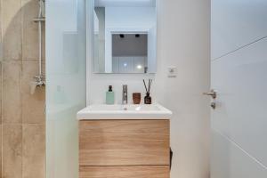 ein Bad mit einem Waschbecken und einem Spiegel in der Unterkunft Luxury 1BR BORN in Barcelona