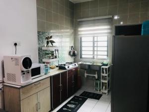 a small kitchen with a microwave and a sink at Nur’s Homestay in Kuala Kelawang +11 photos