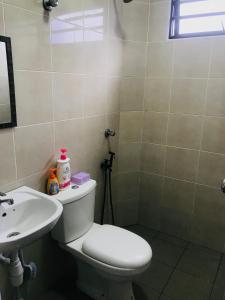 a bathroom with a toilet and a sink at Nur’s Homestay in Kuala Kelawang