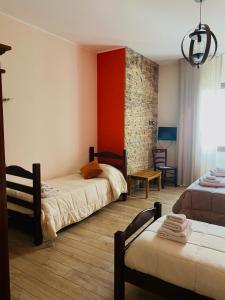 a bedroom with two beds and a red wall at Isolabella in Mazara del Vallo