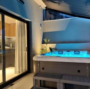 een badkamer met een blauw bad en een douche bij BlueMotion - MediSuite in Piraeus