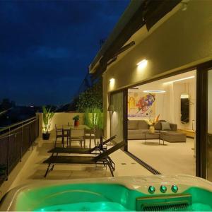 een huis met een hot tub op een balkon 's nachts bij BlueMotion - MediSuite in Piraeus
