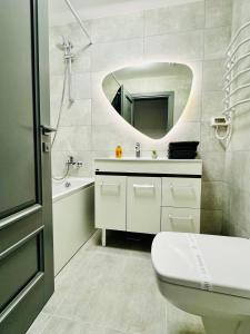 uma casa de banho com um lavatório, WC e um espelho. em Altheda Living Avanera 9B-144 em Suceava