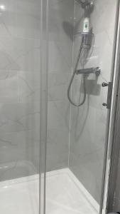 a shower with a glass door with a shower head at Studio flat in London in London