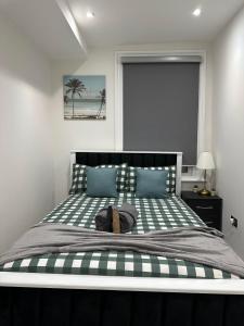 a bedroom with a large bed with green and white stripes at Studio flat in London in London