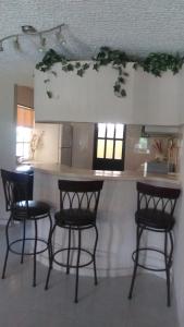 a kitchen with three bar stools and a counter at BEAUTIFUL HOME FULLY FURNISHED, READY TO RELAX AND 5 MINUTES FROM THE BEACH!! in Ixtapa
