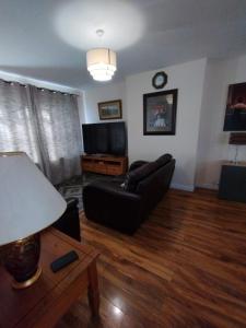 a living room with a couch and a flat screen tv at Edinburgh Villa 3 bed Rooms House in Edinburgh - Private parking in Edinburgh