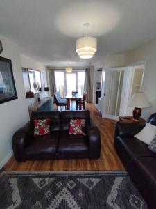 ein Wohnzimmer mit einem Ledersofa und einem Tisch in der Unterkunft Edinburgh Villa 3 bed Rooms House in Edinburgh - Private parking in Edinburgh