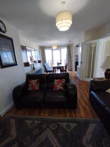 a living room with a leather couch and a table at Edinburgh Villa 3 bed Rooms House in Edinburgh - Private parking in Edinburgh