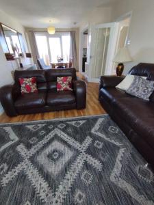 a living room with two leather couches and a rug at Edinburgh Villa 3 bed Rooms House in Edinburgh - Private parking in Edinburgh