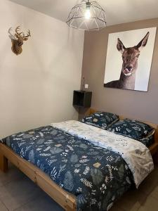a bedroom with a bed with a picture of a deer on the wall at Gîte la biche des écrins in Prunières