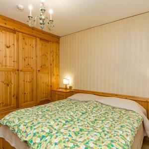 - une chambre avec un lit et un lustre dans l'établissement Hotel Pontechiesa, à Cortina dʼAmpezzo