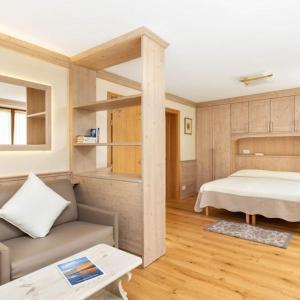 1 dormitorio con 1 cama y 1 sofá en una habitación en Hotel Pontechiesa, en Cortina dʼAmpezzo