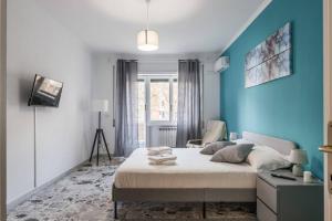 1 dormitorio con cama y pared azul en Ostiense Apartment Self check-in, en Roma