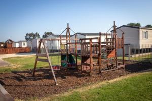 a playground with a swing set in a yard at Sheerness Holiday Caravan for 6 in Sheerness
