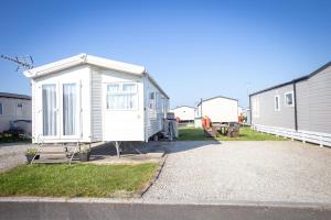 a tiny house sitting on the side of a road at Sheerness Holiday Caravan for 6 in Sheerness