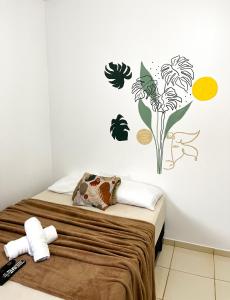 a bedroom with a bed with flowers on the wall at Pousada Marajó For You in Soure