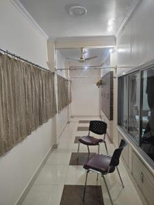a hallway with two chairs and a window at Shree Niwas Home Stay in Varanasi