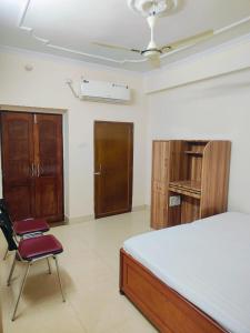 a bedroom with a bed and a chair in it at Shree Niwas Home Stay in Varanasi