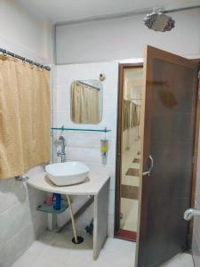 a small bathroom with a sink and a shower at Shree Niwas Home Stay in Varanasi