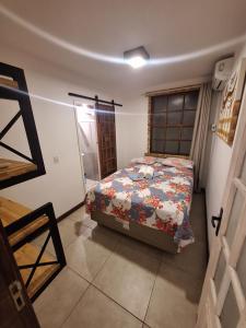a bedroom with a bed with a floral comforter at CASA 2/4 PRAIA DO FORTE!!!! LOCALIZAÇÃO PRIVILEGIADA!!! in Praia do Forte