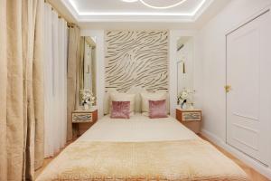 a bedroom with a large bed with pink pillows at Bretagne Mairie du 3e in Paris