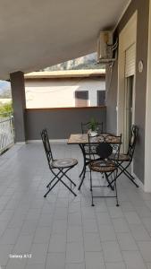 eine Terrasse mit einem Tisch und Stühlen auf dem Balkon in der Unterkunft Villino Lufina in Carini