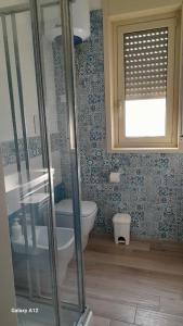 ein Bad mit einem WC und einem Fenster in der Unterkunft Villino Lufina in Carini