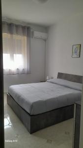 ein Schlafzimmer mit einem großen Bett und einem Fenster in der Unterkunft Villino Lufina in Carini