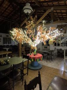 a dining room with lights hanging from a tree at Aldeia Parque Pousada Rural in São Roque +58 photos