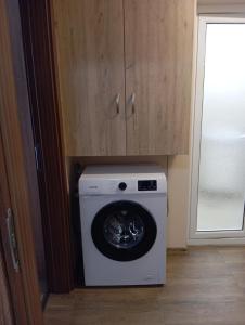 a washing machine in a kitchen next to a door at Cozy New Apt - Уютен апартамент in Blagoevgrad