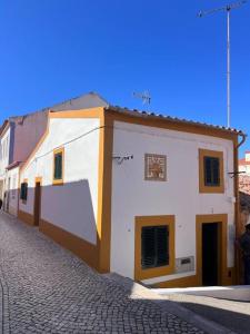 馬夫拉的住宿－Casa da Vila - Vila de Mafra，鹅卵石街道上的白色建筑