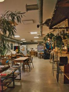 uma sala de jantar com mesas, cadeiras e plantas em Le Flâneur Guesthouse em Lyon