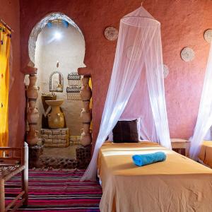 - une chambre avec un lit et une moustiquaire dans l'établissement kasbah hotel Luna, à Erfoud
