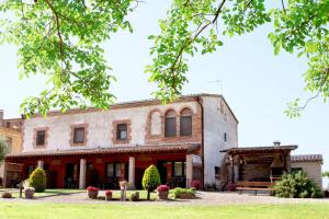 ein altes Gebäude mit einer Bank davor in der Unterkunft Can Pujol - Turismo Rural in Serra de Daró