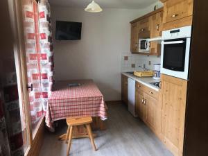 une petite cuisine avec une table avec une nappe à carreaux rouges dans l'établissement Beau 3 pièces avec vue Montana 4, à Pralognan-la-Vanoise