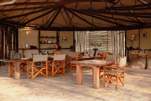 a dining room with wooden tables and chairs at Kasabushi Camp in Chunga