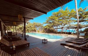 um deck com cadeiras e uma piscina em Bohemia Beach Tayrona em Guachaca