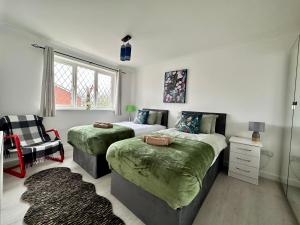 a bedroom with two beds and a chair at Fennec 4-BR Detached House, Sleeps 6, Free Parking in Cambridge