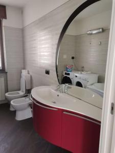ein Badezimmer mit einem Waschbecken, einem WC und einem Spiegel in der Unterkunft Da Laura in Grosio