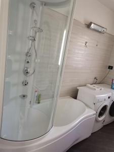 ein Bad mit einer Dusche und einer Waschmaschine in der Unterkunft Da Laura in Grosio
