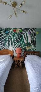 a bedroom with two beds and a green leafy wall at Cheltenham race accommodation for Cheltenham Festival in Southam