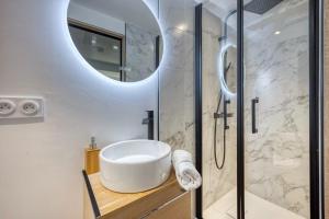 a bathroom with a white sink and a mirror at Le VH in Grenoble